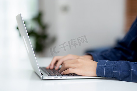 在家工作的商人之手，使用笔记本电脑在办公桌上上网，新常态的生活方式，社交距离，自由职业者在家工作，员工在室内使用笔记本电脑。