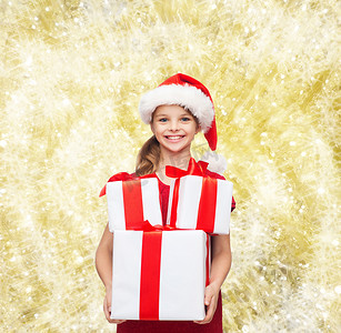 带着礼物的圣诞老人助手帽子微笑的小女孩