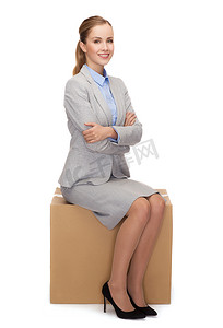 坐在纸箱上微笑的女人