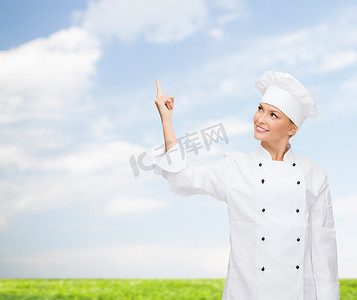 利用某物摄影照片_微笑的女厨师用手指指着某物