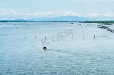 海滩奔跑的美摄影照片_与渔民农场一起在海上奔跑的小船