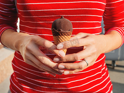穿红衬衫的女人拿着冰淇淋。