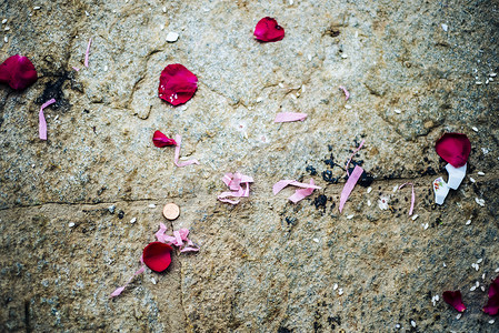 带玫瑰花瓣硬币和粉红色纸的石头背景