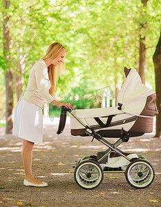 公园里推着婴儿车的快乐妈妈