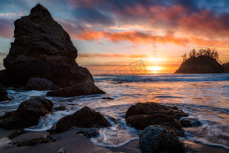 在岩石太平洋西北海滩的日落