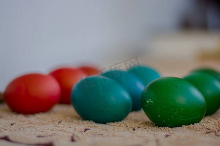 红色、蓝色和绿色的一排排五颜六色的复活节彩蛋正在等待油漆变干。