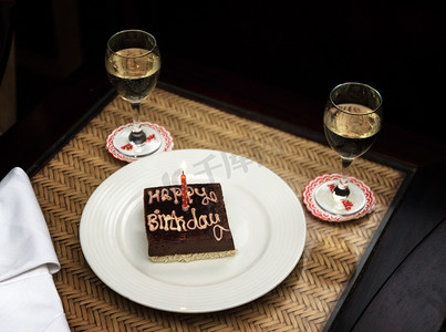 生日蛋糕方形摄影照片_一个小方形巧克力生日蛋糕，上面刻着 happ