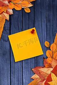 秋天木板背景摄影照片_黄纸上图钉数字图像的合成图像