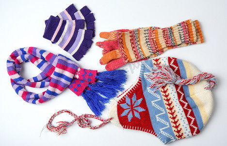 白色背景中的冬帽、手套和彩色针织围巾，