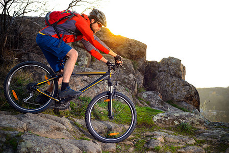 日落时分，骑山地自行车的骑自行车者在春天步道上落基山下。