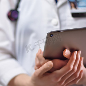专业徽章摄影照片_医疗保健专业人员手中的平板电脑近距离。