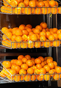 鲜艳水果摄影照片_市场摊位上一堆鲜艳的橙子是成熟多汁的热带水果