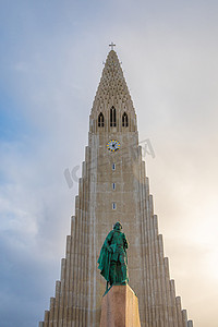 前面后面摄影照片_冰岛雷克雅未克 Hilgrimskirkja Hilgims 教堂在 Lerik Eriksson 纪念碑后面美丽的阳光明媚的日子里