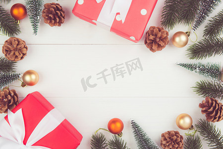 礼物盒框架摄影照片_圣诞假期组合物，在木制背景上装饰红色礼品盒，新年和圣诞节或周年纪念日，在木桌上按季节、顶视图或平躺放置礼物，复制空间。