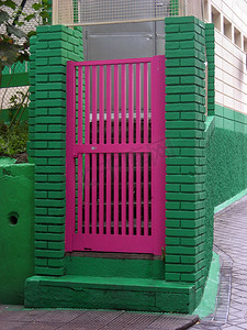 绿色栅栏上的粉红色门