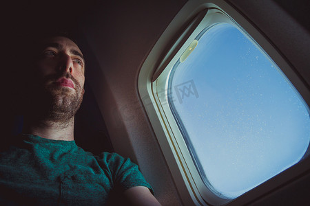 坐在飞机窗边沉思的人