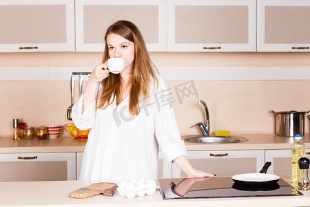 男士长发摄影照片_girla 白色男士衬衫，飘逸长发，正在厨房喝茶