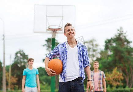 打篮球操场摄影照片_一群微笑的青少年打篮球