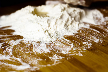 准备揉面和烘烤的木板上的一堆面粉。
