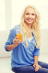 断奶摄影照片_家里拿着一杯橙汁微笑的女人