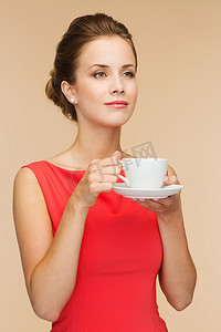 穿着红色连衣裙、端着咖啡微笑的女人
