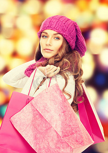 穿着冬装、提着粉色购物袋的女人