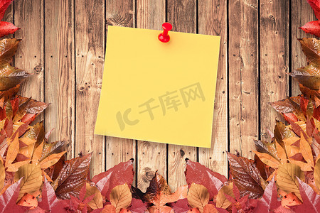 秋天木板背景摄影照片_黄纸上图钉说明性图像的合成图像