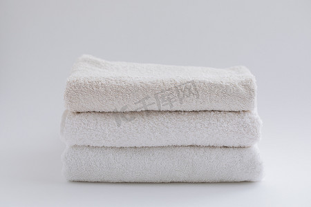 浴室浴巾摄影照片_白色背景上的米色和白色浴巾。