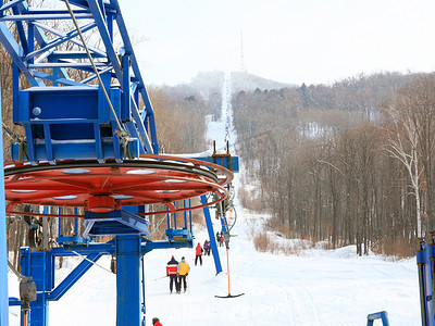 电梯乘坐摄影照片_滑雪者在俄罗斯滨海边疆区的山上乘坐缆车