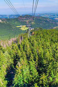 乘坐电梯摄影照片_乘坐缆车穿越山区的森林，美丽的兰