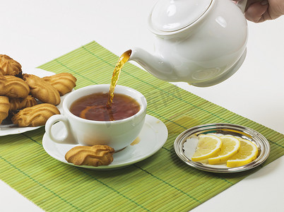 煮茶茶壶摄影照片_柠檬茶和饼干