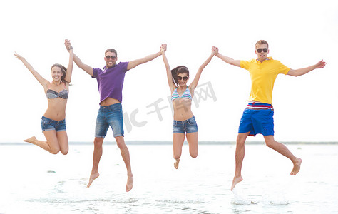 一群朋友或情侣在沙滩上跳跃