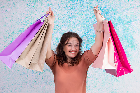 购物时笑得开心的女人拿着彩色纸袋，包