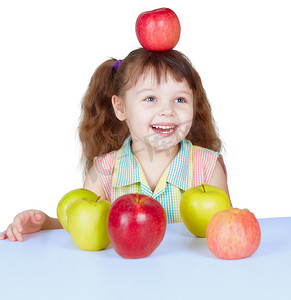 坐在桌边玩苹果的快乐女孩