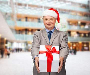 穿着西装的微笑男士和带礼物的圣诞老人助手帽