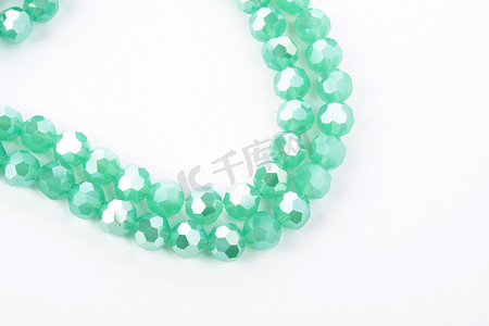 翡翠手镯摄影照片_白色背景上美丽的浅绿色玻璃闪光水晶 Isoalted 珠。