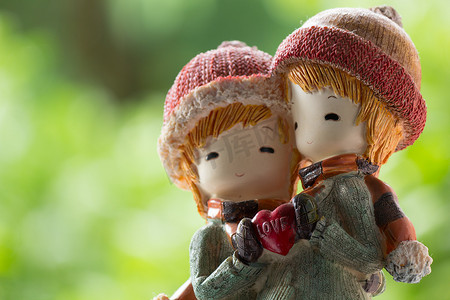 两个洋娃娃冬装拥抱并抱着爱的心