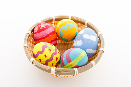 鸡蛋黄色摄影照片_在篮子里手工制作的复活节彩蛋
