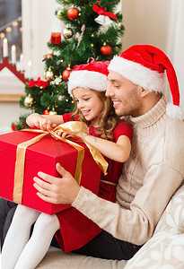 圣诞节打开礼盒摄影照片_微笑的父女打开礼盒