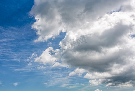 蓝色夏日天空上的厚重的灰色云