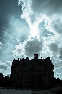 黑暗的剪影看起来可怕的中世纪城堡被太阳照亮