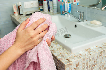 洗摄影照片_男人在浴室里用毛巾擦手，特写
