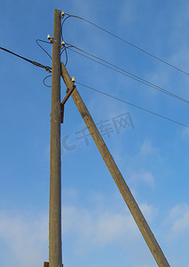 蓝天背景下带电线和绝缘体的 0.4 kV 输电线路的旧木支架，垂直图像