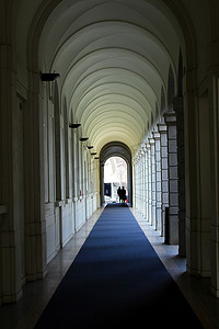 柱廊画廊的透视图，人很少，地板上铺着蓝色地毯（意大利历史建筑现在用作大学）