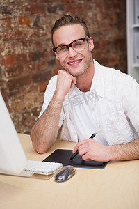 微笑的男人，手托着下巴，在平板电脑上画画