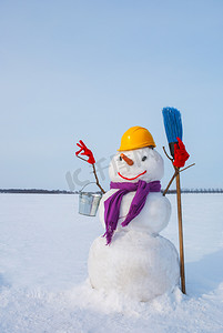 冬天手工雪人摄影照片_在一个多雪的领域的孤独的雪人