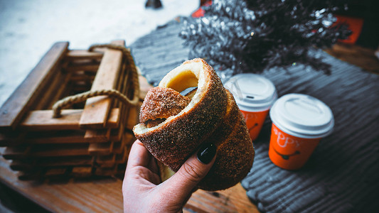 欧洲食品摄影照片_女人手拿 Trdlo 或 Trdelnik，这是布拉格的全国街头食品