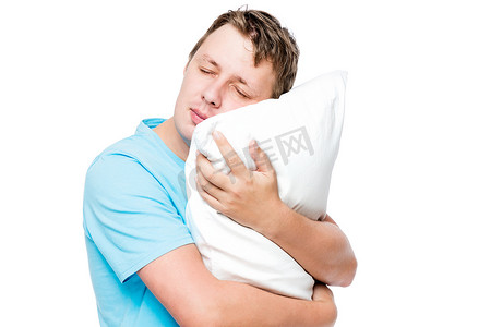 蓝色的枕头摄影照片_白色背景下睡着的人抱着柔软的枕头