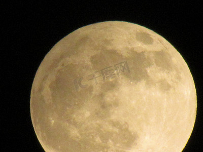黑色月球摄影照片_通过长焦相机拍摄的黑色夜空中的月亮特写。