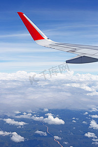 从窗口看飞机的土地、天空、云和​​机翼